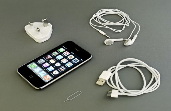 Un smartphone, casti, incarcator si alte accesorii, evidentiind sursele de alimentare disponibile.