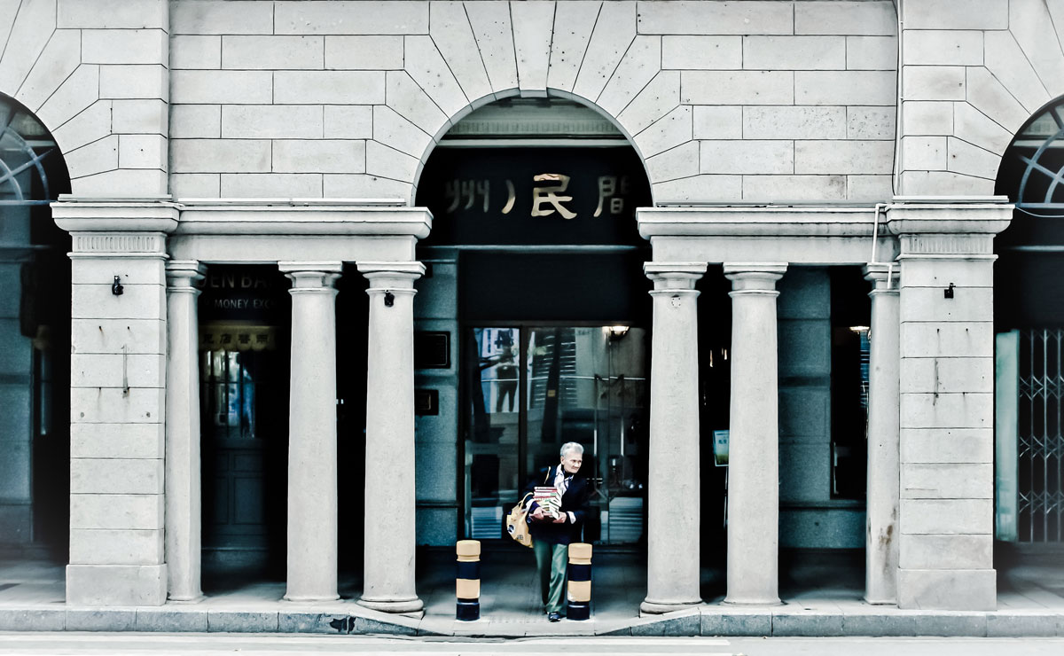 Un barbat iese dintr-o cladire securizata, admirand arhitectura eleganta.