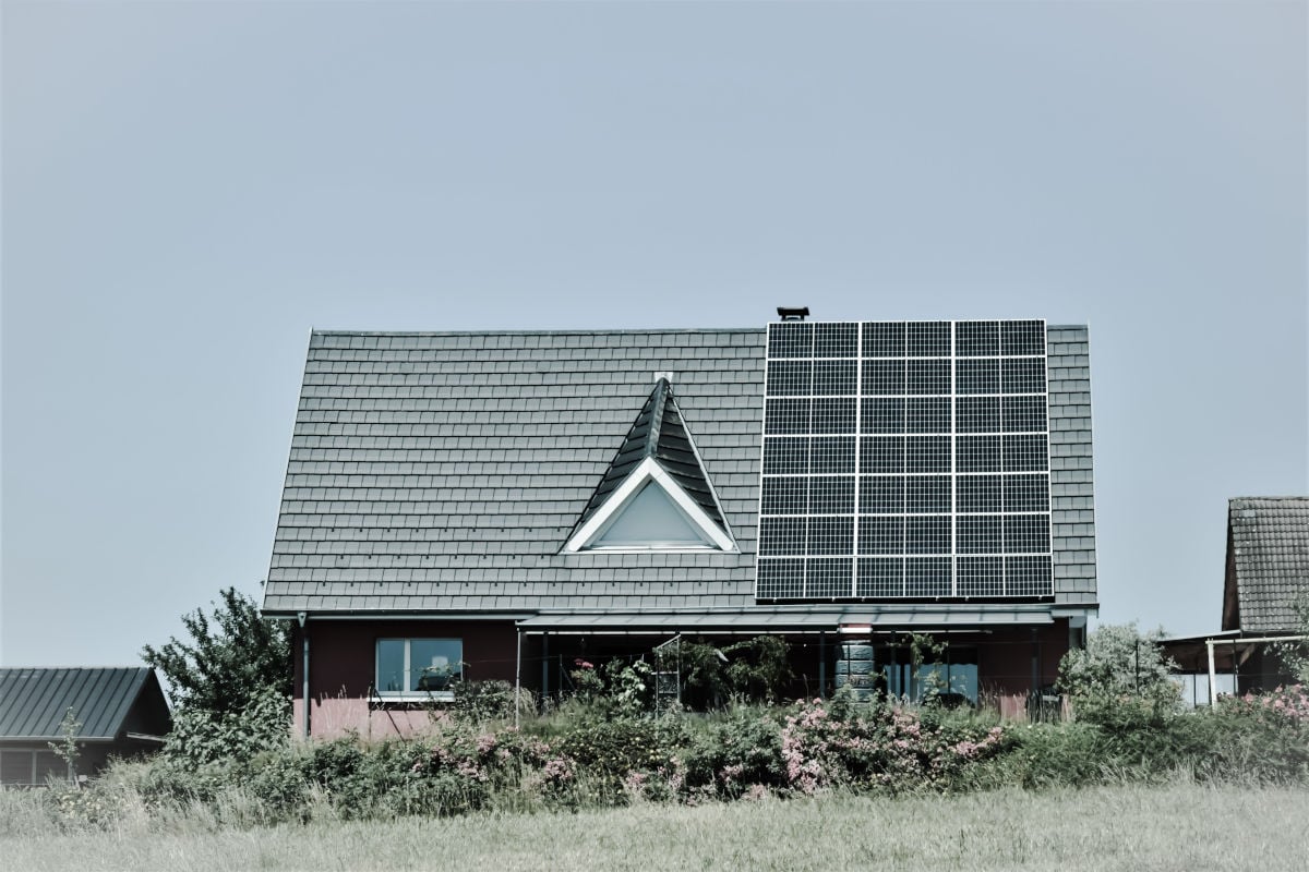 Casa cu panouri solare pe acoperis si invertor solar, evidentiind solutii ecologice pentru energie.