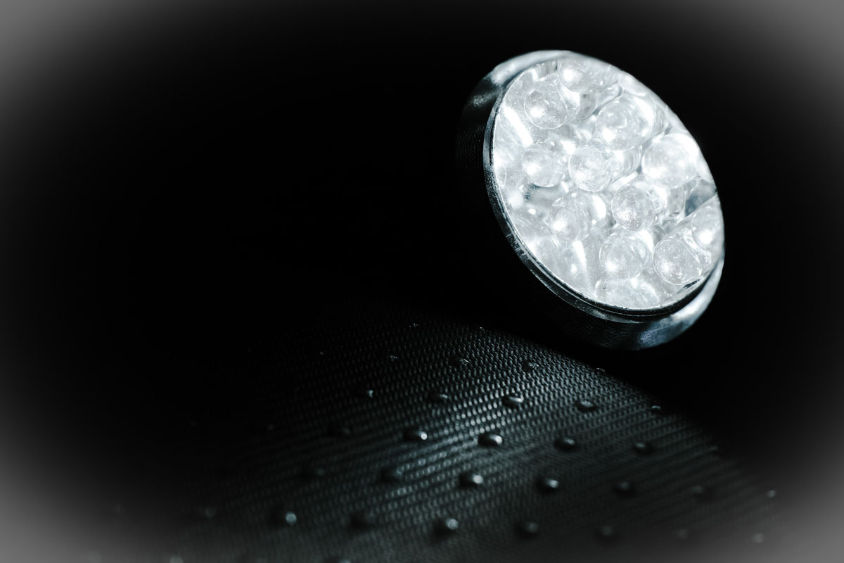 O lampa led ilumineaza o suprafata intunecata, evidentiind textura acesteia.