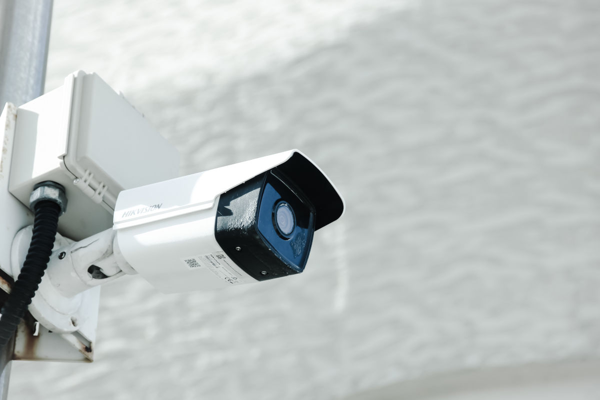 Camera de securitate montata pe un stalp, cu microfon integrat pentru supravegherea eficienta a zonei.