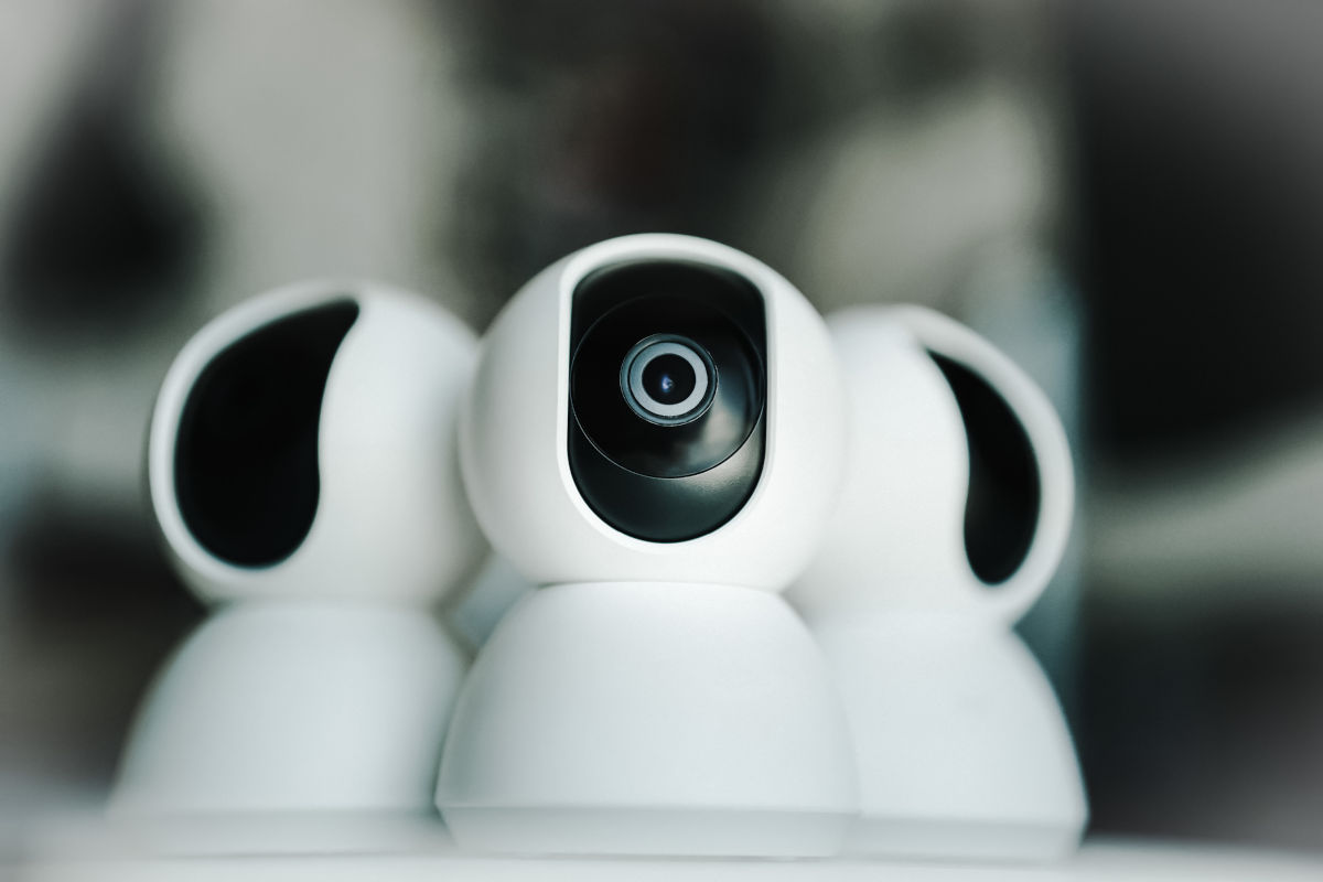 Trei camere de supraveghere IP albe asezate pe o masa, pregatite pentru monitorizare.