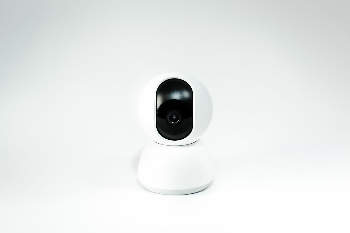  Camera video alb-negru asezata pe o suprafata alba, evidentiind designul sau elegant si modern.