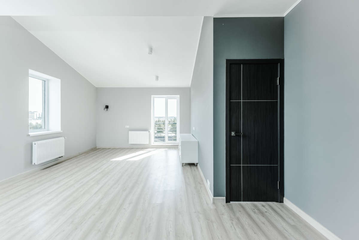 Spatiu liber cu podea din lemn si pereti gri, avand centrala termica cu UPS sinus pur pentru confortul locuintei.