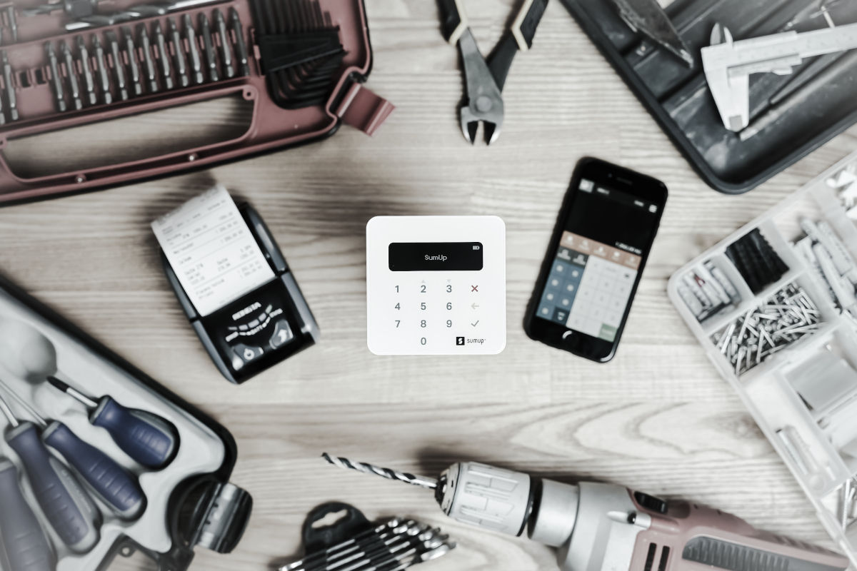O masa cu unelte si un telefon mobil, pregatita pentru reparatii cu trusa de reparat telefoane.