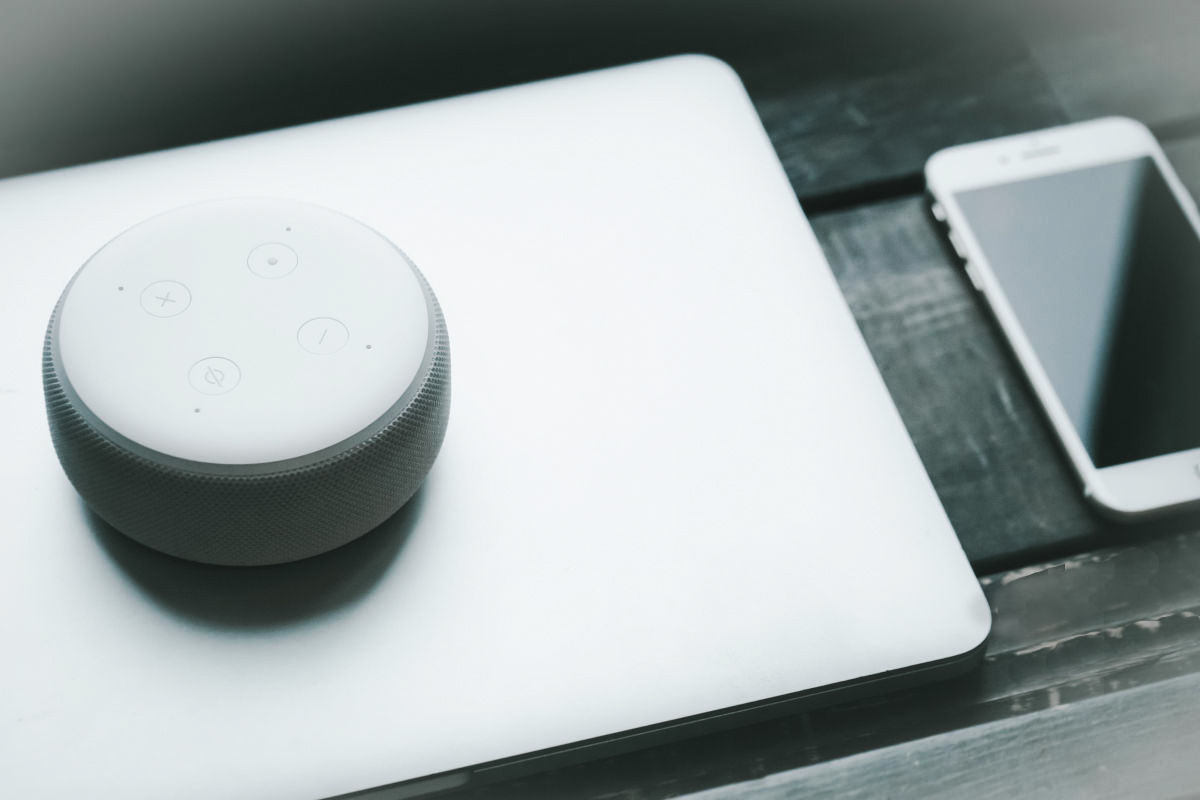 Un dispozitiv tip acces point exterior si un smartphone asezate pe o masa din lemn, servind ca punct de acces pentru tehnologie.