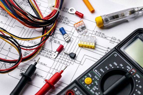 Echipamente electrice si cabluri pe o foaie, ilustrand scule si unelte utile in domeniu.