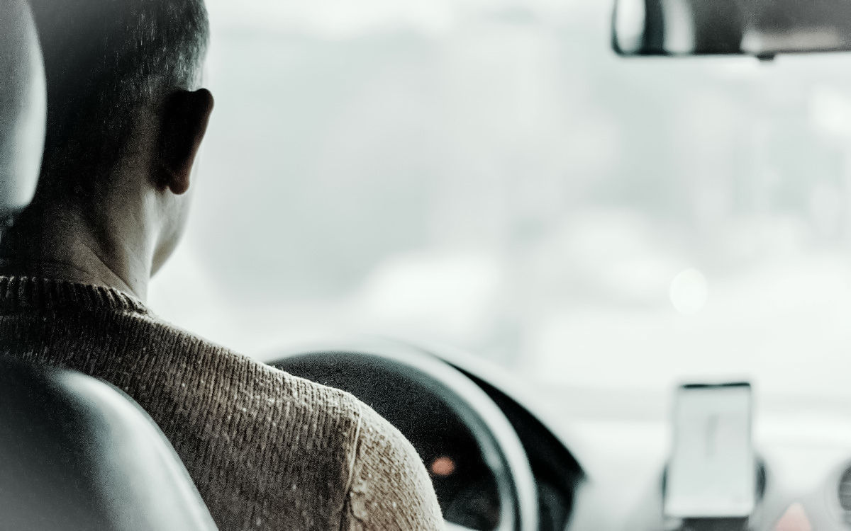 O masina neagra se deplaseaza pe un drum forestier, evidentiind tehnologia avansata de navigatie auto.